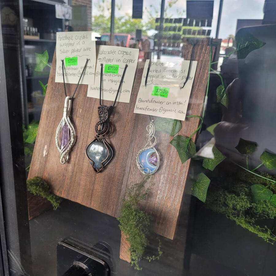 Untitled Showcase of 3 necklaces behind glass window